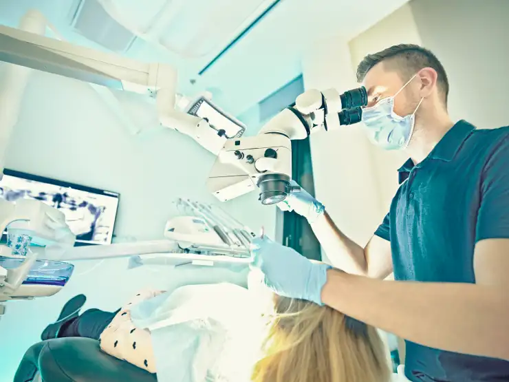 Dentist using a dental microscope for root canal treatment