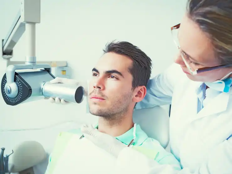 Patient with a rubber dam on a tooth during root canal treatment
